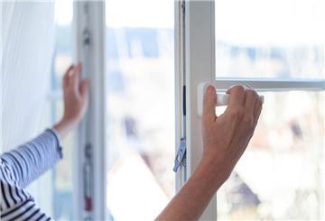 Ein Mensch öffnet ein Fenster.