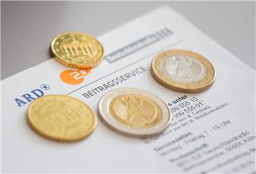 Euromünzen liegen auf einem Anschreiben zur Anmeldung für die Rundfunkgebühren