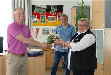 Mit einem Blumenstrauß und mit Abstand beglückwünscht Bürgermeister Detlef Wellbrock (links) Silvia Pauper zu ihrem neuen Amt als Ortsvorsteherin für Bexhövede. Carsten Link, der sich vertretungsweise um das Amt gekümmert hatte, freut sich mit.