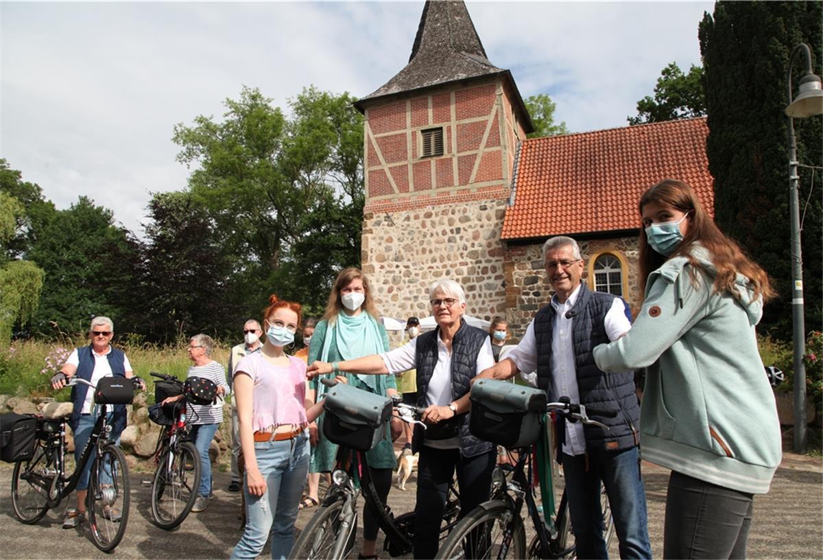 Mit einem Reisesegen schickte Pastorin Lara Schilde morgens in Bexhövede die Teilnehmer von „Kirche auf dem Rad“ auf ihre Tour. Unter ihnen auch Hildegard und Dietmar Hencken aus Sellstedt, die von den Konfirmandinnen Lina (rechts) und Emma mit einem Armband versorgt werden. Foto Gehrke
