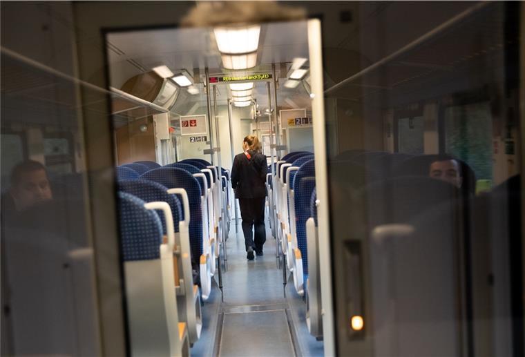 Eine Schaffnerin geht durch einen Regionalzug.