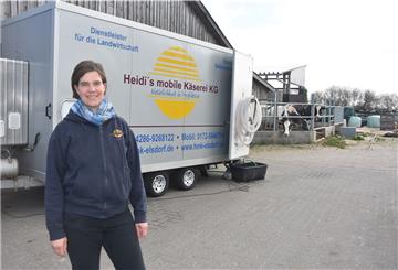 Das Foto zeigt Stephanie Heidrich vor ihrer mobilen Käserei. 