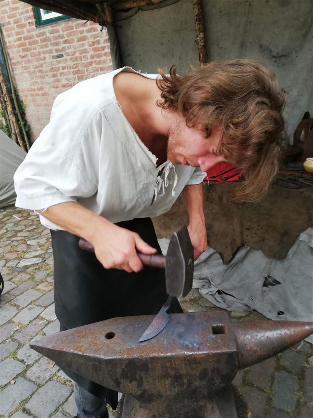 Mit mächtig hartem Hammer schmiedet Geselle Richard aus Bremen heiße Messer auf ...
