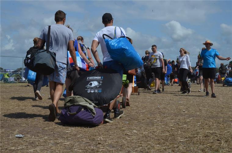 Mit Sack und Pack geht's für zahlreiche Deichbrand-Besucher am Sonntag zu den Parkplätzen.