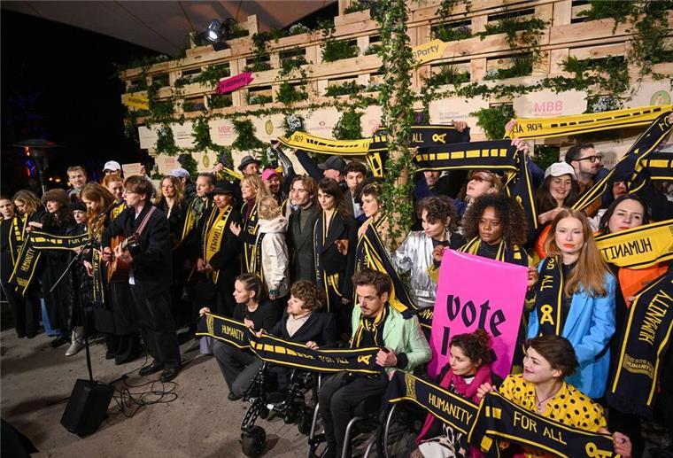 Mit Schals und Schildern haben Prominente an einer Protestaktion von SOS Humanity teilgenommen.