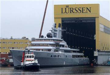 Ein Schlepper zieht eine Yacht aus einem Baudock