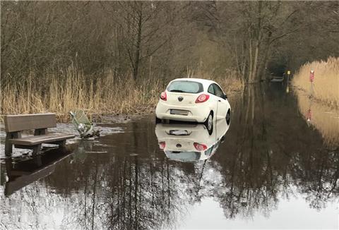 Mit seinem weißen Kleinwagen hat sich der 84-Jährige im Wümme-Hochwasser festgefahren.