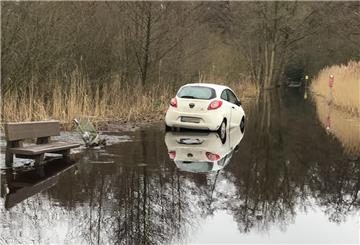 Mit seinem weißen Kleinwagen hat sich der 84-Jährige im Wümme-Hochwasser festgefahren.