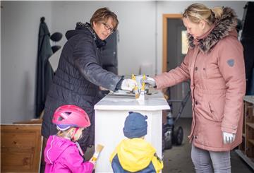 Mit weißem Holzlack streichen Yvonne Holst, ihre Schwiegermutter Anja Voss sowie die Kinder Fiete und Lotta das gebraucht gekaufte Sideboard, welches später im Wohnzimmer des neuen Hauses Platz finden soll. Foto: Hartmann