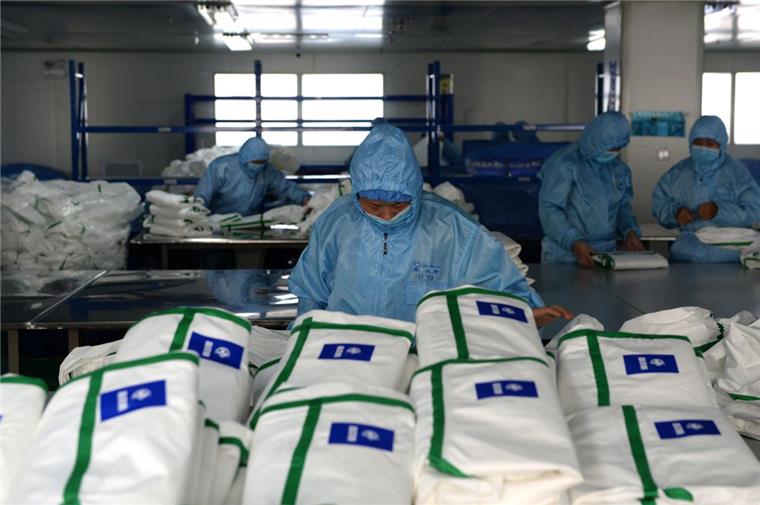 Mitarbeiter eines medizinischen Unternehmens in China produzieren neue  Schutzanzüge. Die Zahl der Infektionen und Todesopfer durch die Lungenkrankheit aus China ist erneut gestiegen. Das Auswärtige Amt hat eine Reisewarnung ausgesprochen.  