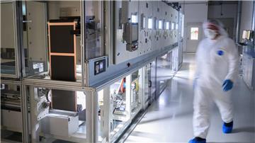 Mitarbeiter stehen in einer Pilotanlage zur Batteriezellenproduktion im VW-Werk Salzgitter an einer Beschichtungsanlage für Elektroden.