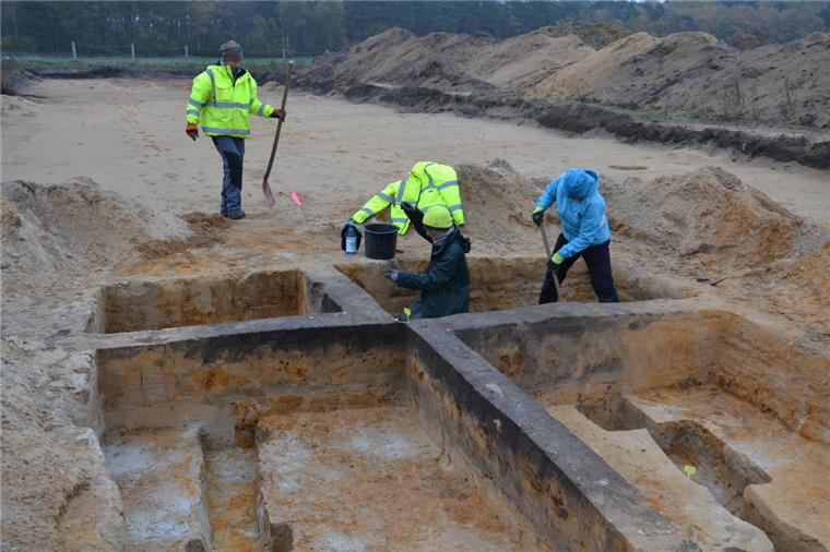 Mitarbeiterinnen des Grabungsteams legen auf der Kuppe des Hexenberges Bodenfunde frei, die auf ein Grubenhaus hindeuten. Beim Freilegen sind sie auf Keramikscherben gestoßen. In Grubenhäusern haben die Siedlungsbewohner Handwerk versehen. Die Nutzung dieses Hauses ist den Archäologen noch unklar.