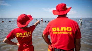 Mitglieder der DLRG (Deutsche Lebens-Rettungs-Gesellschaft) stehen am Strand von Dangast.