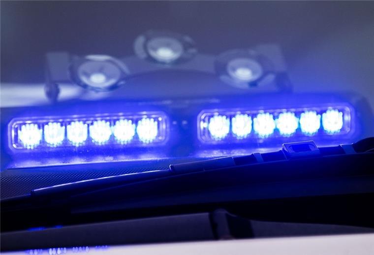 Ein Blaulicht leuchtet unter der Frontscheibe eines Einsatzfahrzeugs der Polizei.