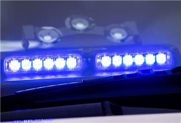 Ein Blaulicht leuchtet unter der Frontscheibe eines Einsatzfahrzeugs der Polizei.