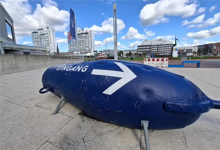 Eine blaue Fahrwassertonne mit dem Schriftzug "Eingang" und einem großen Pfeil.