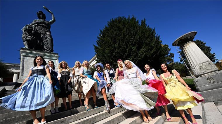 Die Dirndl-Trends 2024: Samtig und farbenfroh Models in verschiedenen Dirndl-Modellen posieren vor der Bavaria (Foto Produktion).