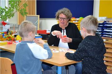 Monika Bammann, Konrektorin der Janusz-Korczak-Schule, übt mit zwei Schülern anhand von Karten die korrekte Aussprache der Buchstaben R, L, J, H und K. Nach zehn Minuten gehen die beiden Jungs zurück in ihre Klasse und zwei ihrer Klassenkameraden nehmen im Therapieraum Platz.
