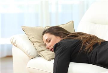 Eine Frau schläft auf der Couch. Müde, obwohl du genug schläfst? Ein Mangel an bestimmten Vitaminen kann der Grund sein – ein Bluttest bringt Klarheit.