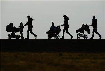 In einem Schattenrist ist zu sehen, wie drei Erwachsene jeweils einen Kinderwagen schieben, in dem Kinder sitzen.
