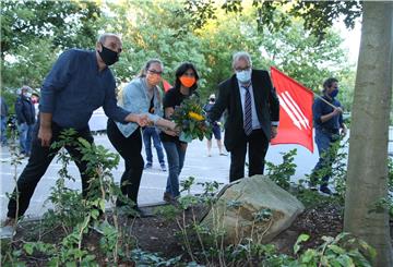 Mustafa Dogan (DGB Nordenham), Ömer Sayan und Merle Kauschmann (Grüne Jugend Wesermarsch) und Bürgermeister Carsten Seyfarth (von links) legten Blumen an der sogenannten Friedenseiche nieder. Foto: Lorenz