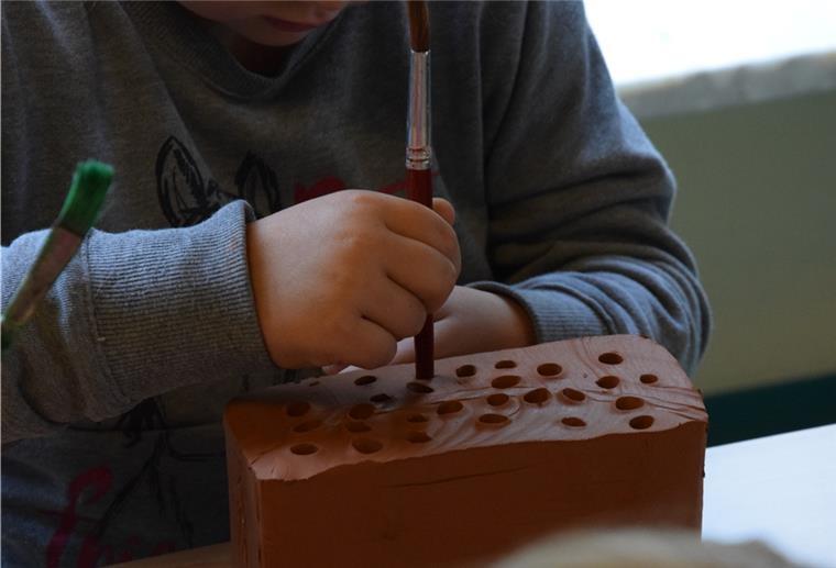 Nabu-Projekt im Kindergarten: Mit Pinseln stechen die Mädchen und Jungen längliche Hohlräume als Nisthilfe für Wildbienen in die Tonblöcke.