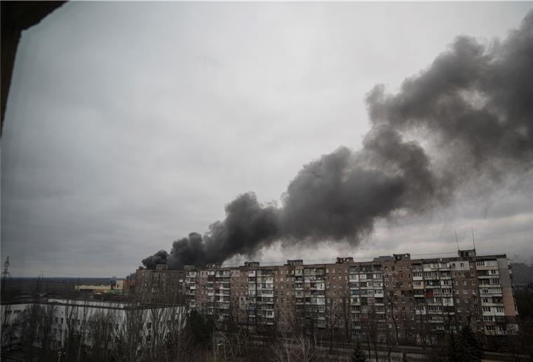 Nach Beschuss durch russische Streitkräfte in Mariupol steigt Rauch aus einem Wohnblock auf.
