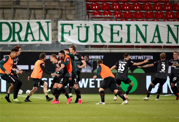 Männer auf Rasen, Fußballer jubeln.