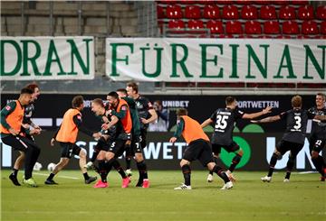 Männer auf Rasen, Fußballer jubeln.