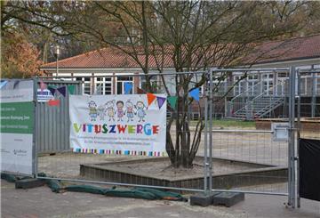 Ein Schild der Kita Vituszwerge an einem Bauzaun.