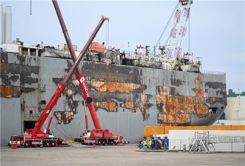 Der schwer beschädigte Autofrachter »Fremantle Highway« liegt mit geöffneten Toren im Hafen.