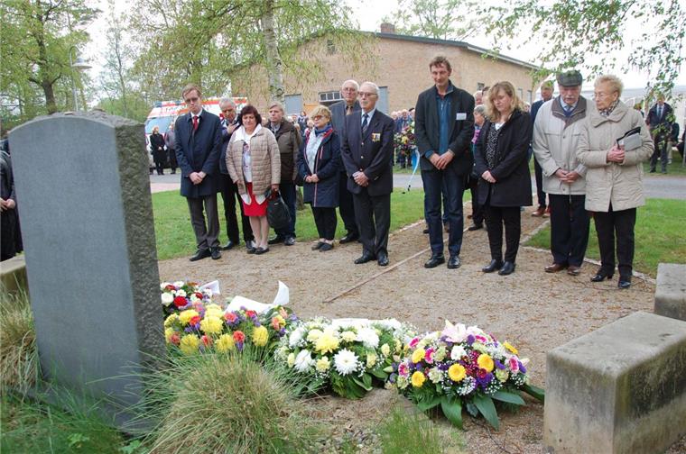 Nach dem Gedenken legten viele der Besucher Kränze oder Blumen am Gedenkstein vor der Lagerkirche in Sandbostel nieder.
