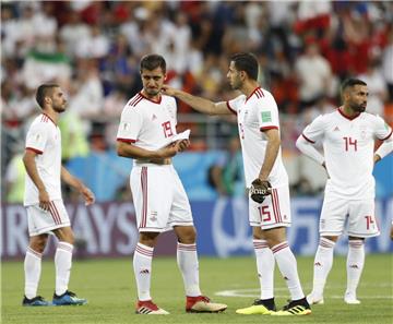 Nach dem Vorrunden-Aus tröstet  Irans Spieler Pejman Montazeri (2.v.r.) seinen Mannschaftskollegen Majid Hosseini (2.v.l.), der nur aufgrund einer skurrilen Gegebenheit zum Einsatz kam.