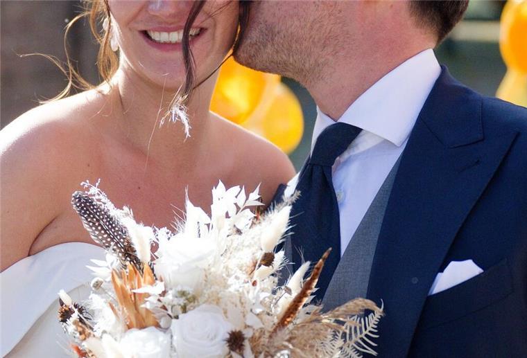 Nach der Hochzeit küsst Joe Laschet vor der Kirche seine Frau Andrea 