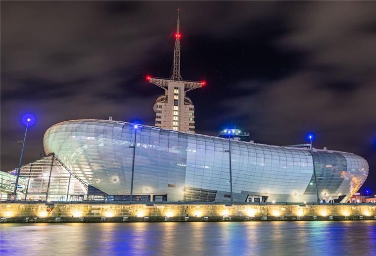 Ausstellung thematisiert im Bremerhavener Klimahaus Energiewende Das Klimahaus in Bremerhaven bei Nacht mit Beleuchtung.