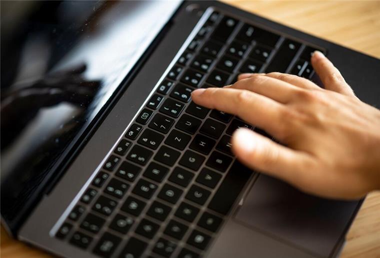 Skandal um Politiker: Anzeige wegen Facebook-Post von Sexpuppe mit Nazi-Symbol ILLUSTRATION - Ein Mann tippt auf einer Tastatur eines Laptops. (zu dpa: «Anzeige wegen Foto mit Nazisymbol - Austritt aus der CDU»)