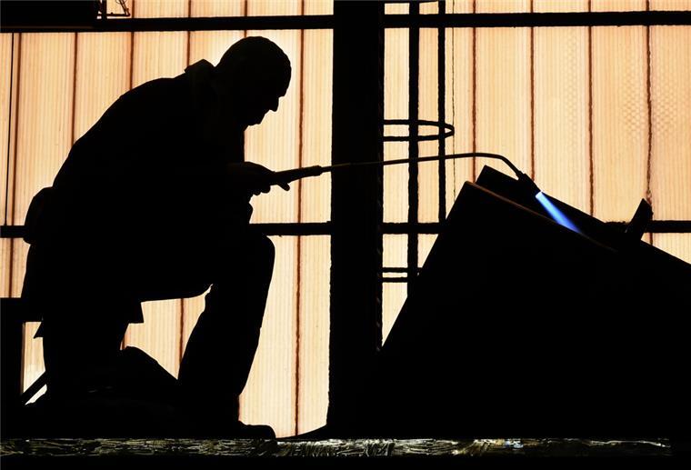 IG Metall sieht Werftindustrie in bedrohlicher Abwärtsspirale In einer Schiffswerft bearbeitet ein Schweißer in Schutzkleidung tonnenschwere Brückenteile.