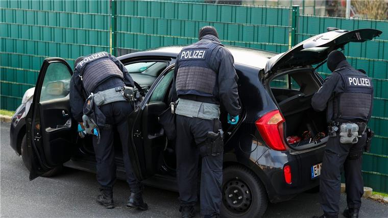 Polizei durchsucht Wohnungen von gewaltbereiten Fußballfans Nach Sonderzug-Gewalt: Polizeibeamte durchsuchen mehrere Pkw vor einem Wohnhaus.