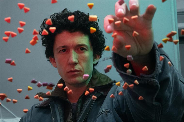 Ein junger Mann greift nach scheinbar schwebenden Pillen, die jeweils eine Dreieckform haben. Nach vier Jahren Pause: „How To Sell Drugs Online (Fast)“ kehrt zurück. Verpasst Moritz  (Maximilian Mundt) den Anschluss an die digitale Welt?