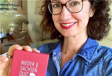Eine Frau hält ein Spiel in der Hand.