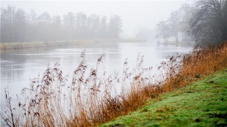 Wetter bleibt unbeständig mit Regen Nebel und Regenwolken ziehen am Morgen bei trübem Wetter über die Hunte am Achterdiek.
