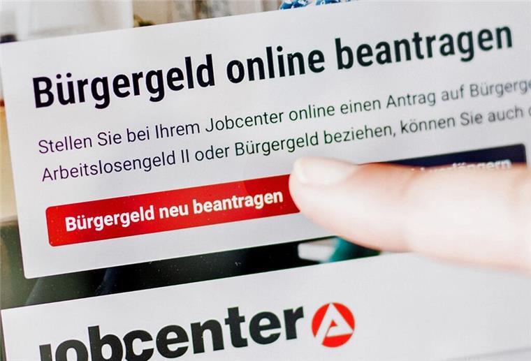 Eine Frau tippt auf einem Tablet auf einen Link zum Beantragen des Bürgergeldes.