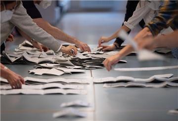 Wahlhelfer und Wahlhelferinnen zählen in einem Wahllokal Stimmzettel für die Bundestagswahl. (zu dpa: «Region Hannover: Jeder Tag bis zur Neuwahl hilft»