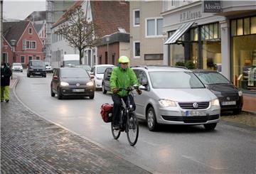Radfahrer und Auto auf schmaler Straße