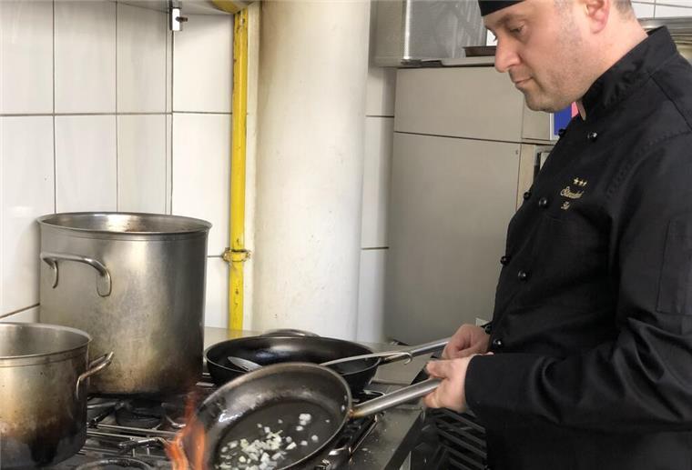 Heftige Nachzahlung: Bremerhavener Gastronom ist wütend Der Koch des Scala brät Zwiebeln in einer Pfanne an.