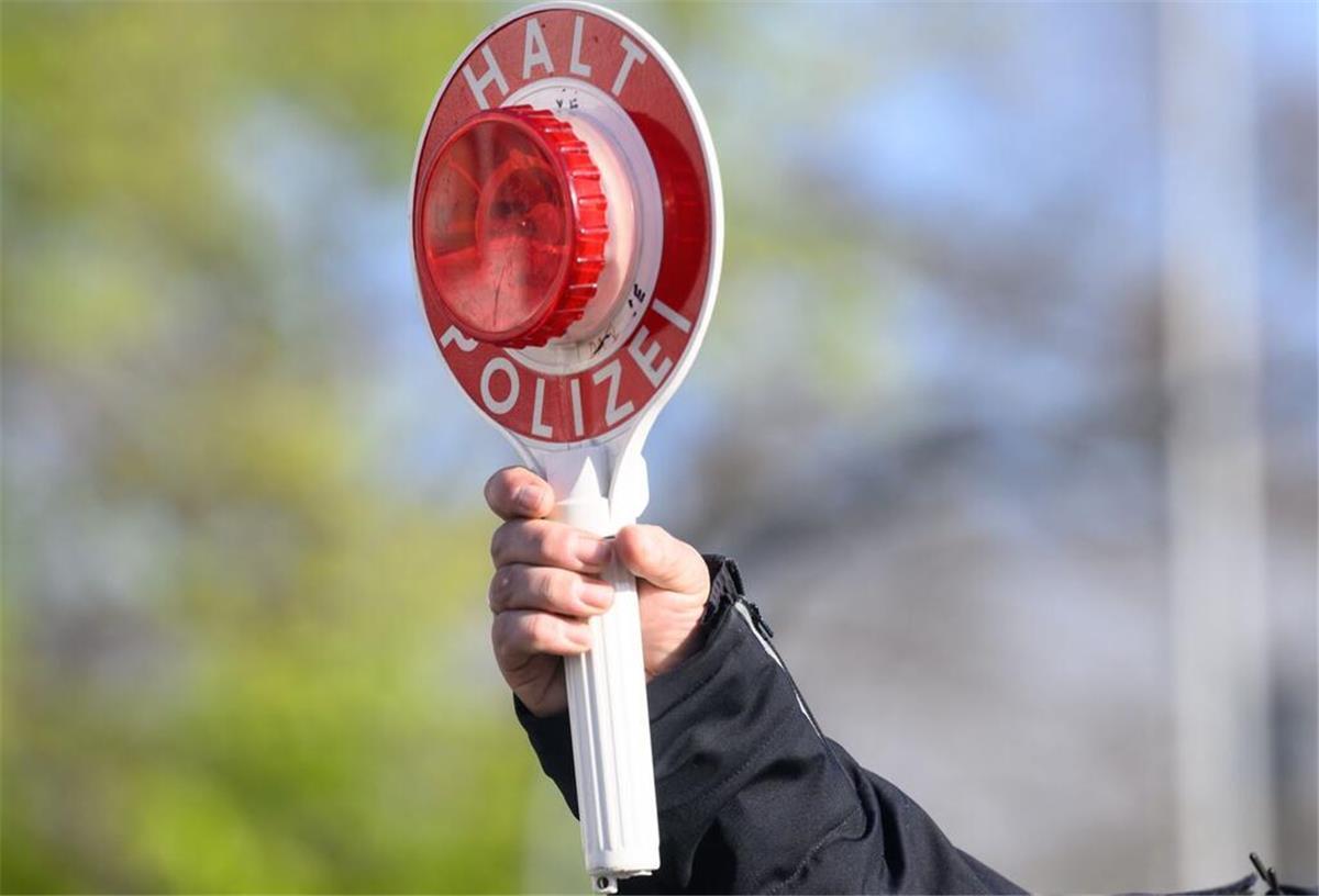 Lebenslanger Führerscheinentzug: Wann die härteste Strafe im Verkehrsrecht droht Ein Polizist hält eine Verkehrskelle in die Luft. Bei einigen Verstößen im Verkehrsrecht kann sogar ein lebenslanger Führerscheinentzug drohen.