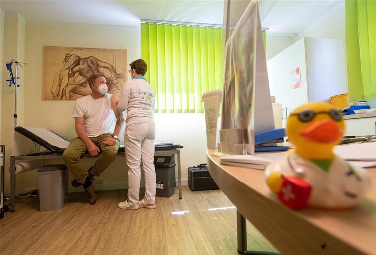 Eine Hausärztin behandelt einen Patienten. 