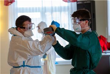 Sachsen, Rathmannsdorf: Zum Schutz vor dem Virus werden der Schutzanzug mit Klebeband luftdicht verschlossen. Die Bewohner der Gemeinde Rathmannsdorf im Landkreis Sächsische Schweiz-Osterzgebirge werden auf das SARS-CoV-2-Virus (Coronavirus) getestet. 
