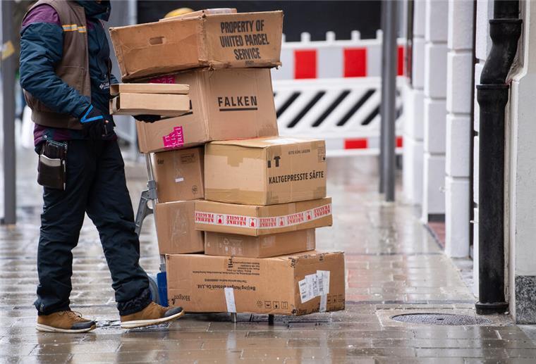 Ein Paketbote liefert Pakete aus.