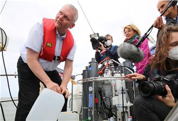 Niedersachsens Wissenschaftsminister Bernd Thümler besucht die Forschenden des Projekts „Gute Küste“. Björn Thümler, niedersächsischer Minister für Wissenschaft, beim Abfüllen der Wasserproben mit einem Tross Reporter.